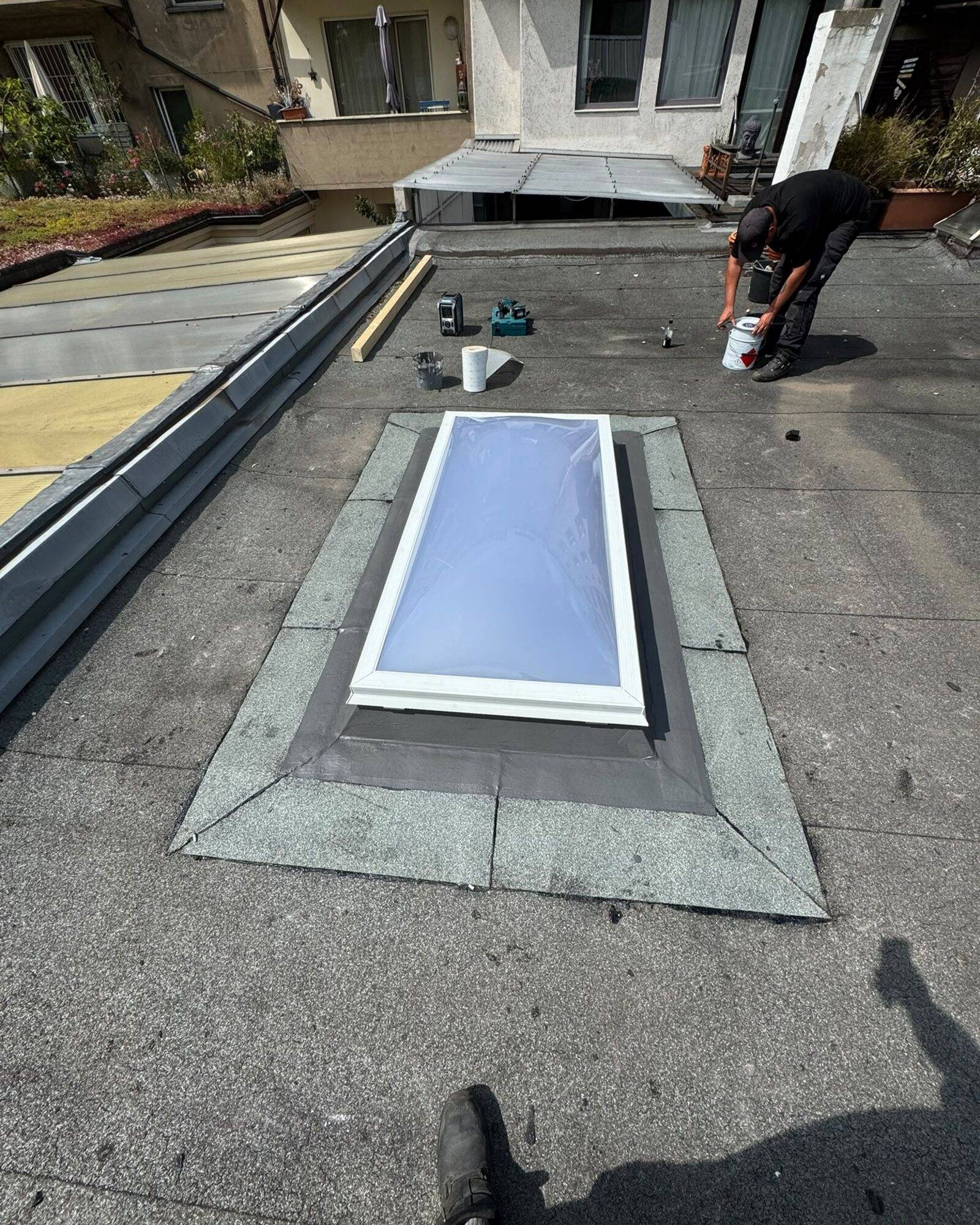 Dachdecker bei Arbeiten an einer Lichtkuppel auf einem Flachdach