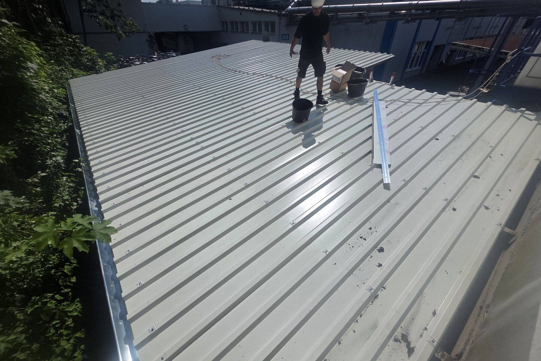 Dachdecker auf einem Dach aus Trapezblech